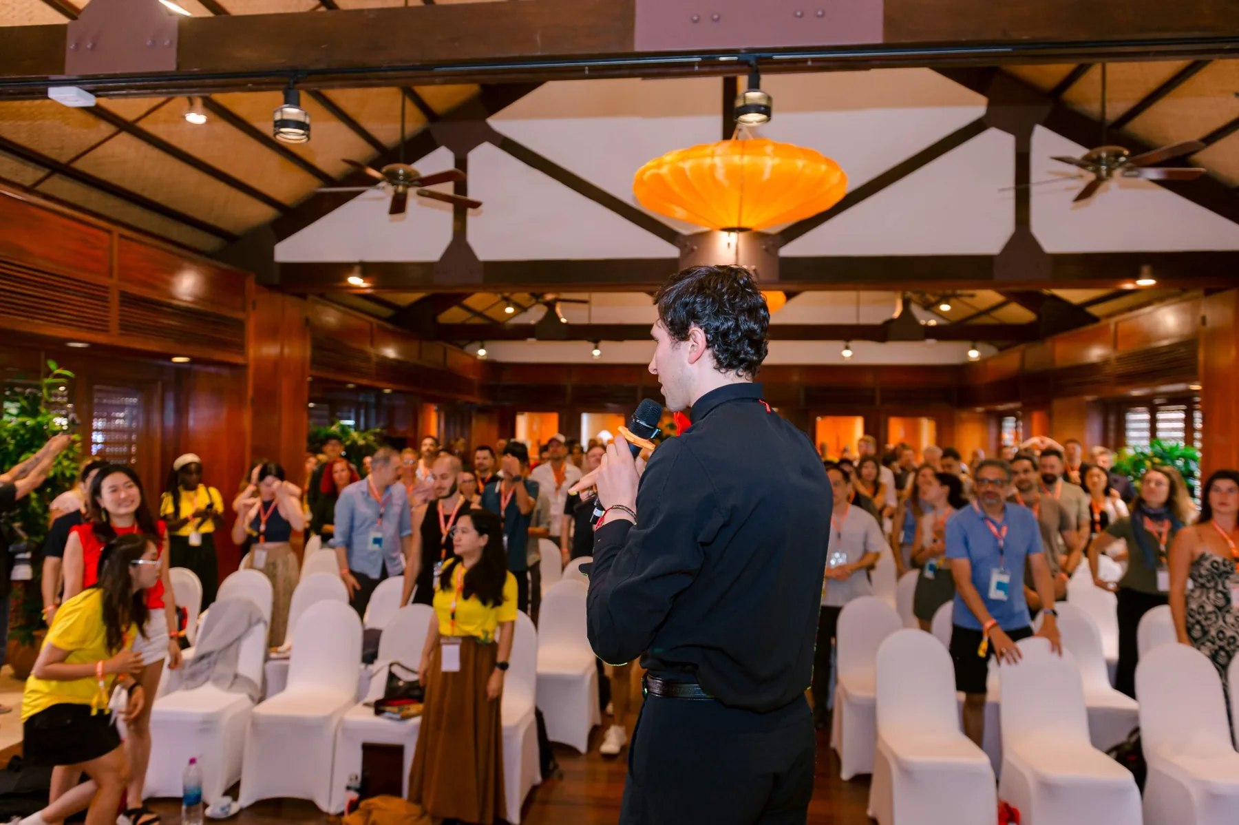 Jacques speaking on stage at a Joymaker Camp, addressing a packed room of participants