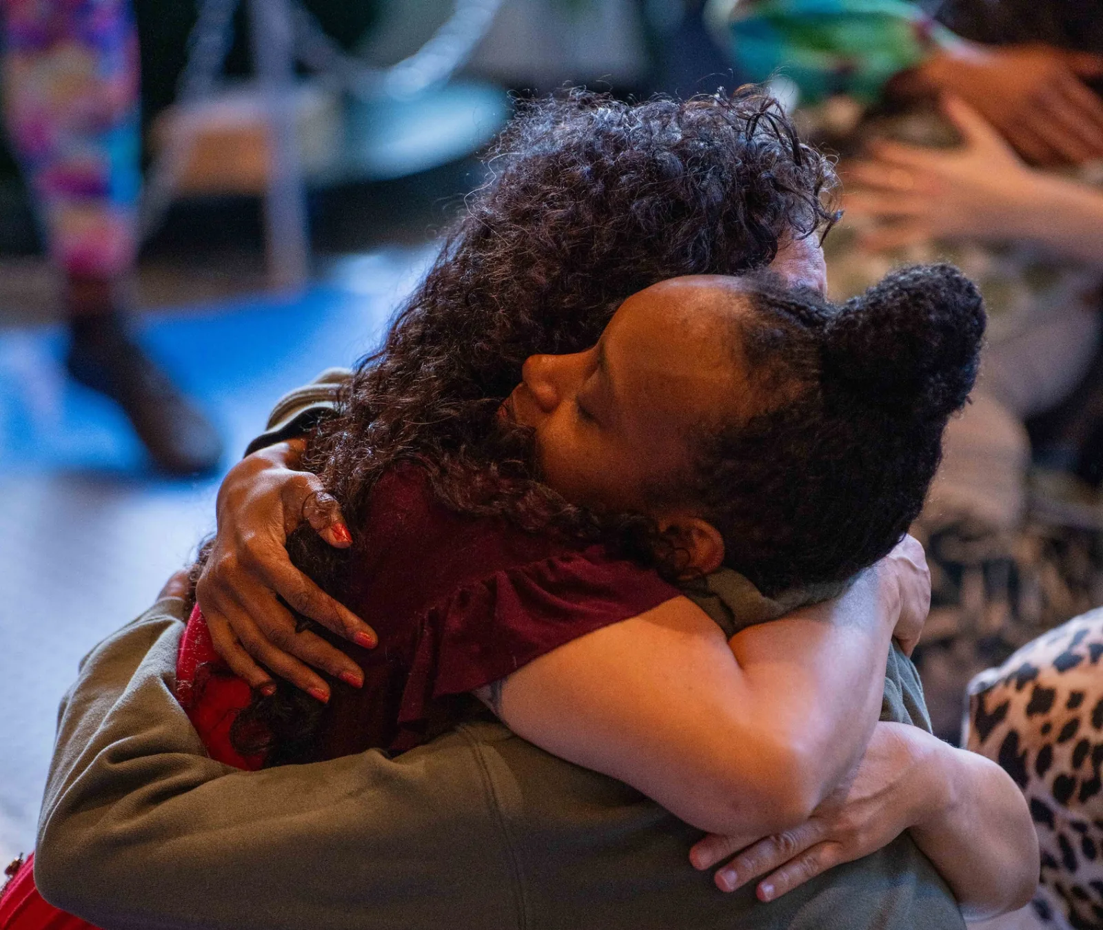 Two attendees in a deep, tender hug during a joy activation