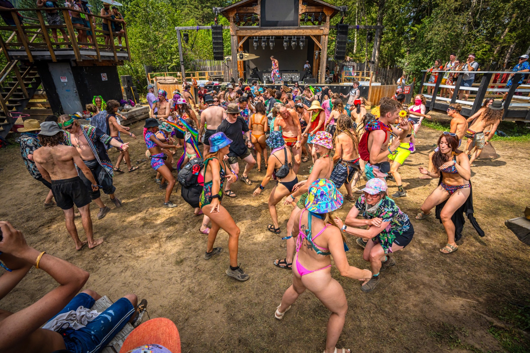 Festival attendees dancing together during a joy activation at an outdoor stage
