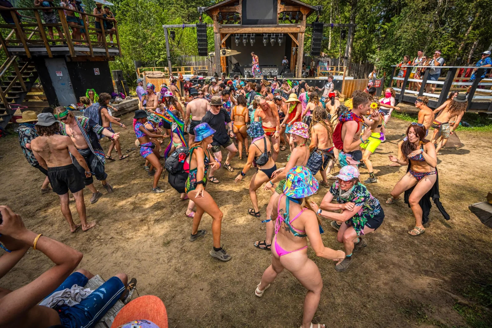Festival attendees dancing together during a joy activation at an outdoor stage